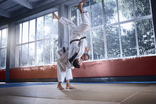 istock Two judo fighters showing technical skill while practicing martial arts in a fight club 1015518874