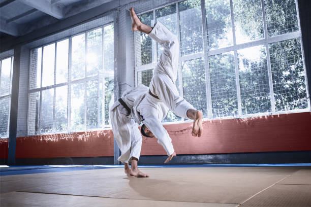 istock Two judo fighters showing technical skill while practicing martial arts in a fight club 1015519100