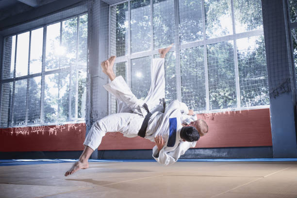 istock Two judo fighters showing technical skill while practicing martial arts in a fight club 1015519606