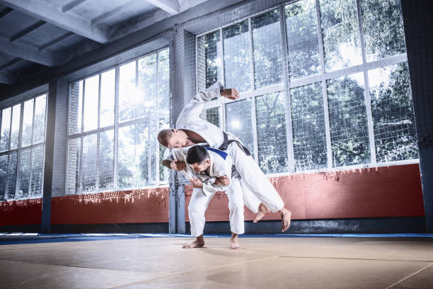 istock Two judo fighters showing technical skill while practicing martial arts in a fight club 1015519704