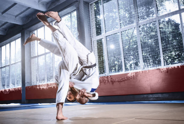 istock Two judo fighters showing technical skill while practicing martial arts in a fight club 1015523900
