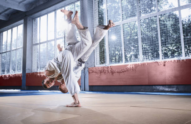 istock Two judo fighters showing technical skill while practicing martial arts in a fight club 1015524386