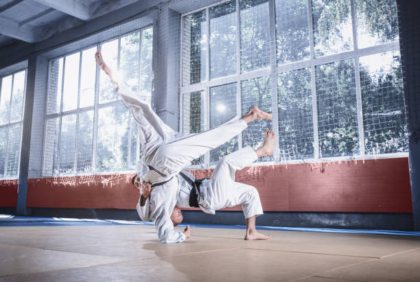 istock Two judo fighters showing technical skill while practicing martial arts in a fight club 1015533802