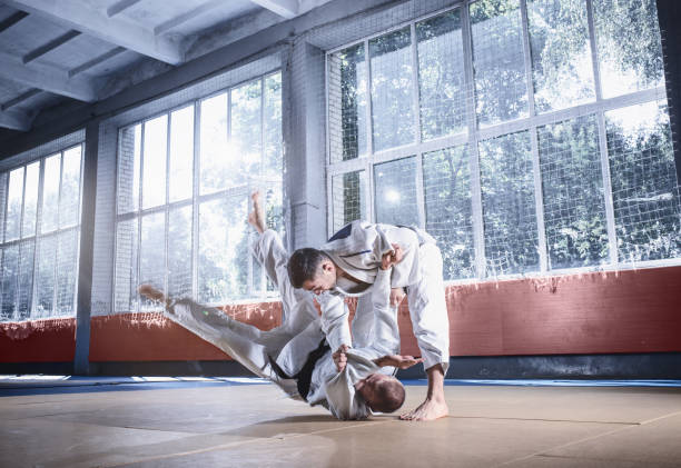 istock Two judo fighters showing technical skill while practicing martial arts in a fight club 1015534852