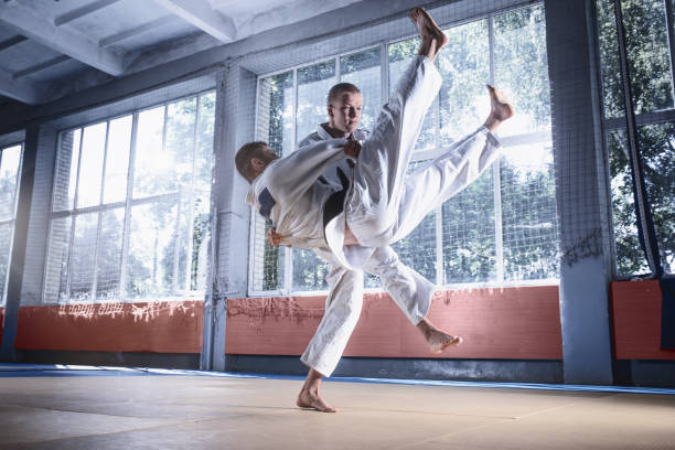 istock Two judo fighters showing technical skill while practicing martial arts in a fight club 1015537320