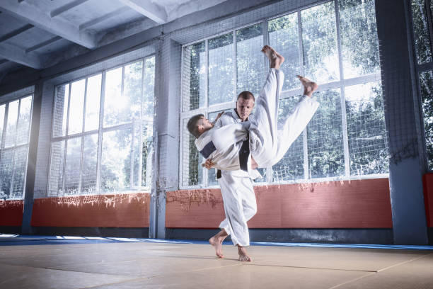 istock Two judo fighters showing technical skill while practicing martial arts in a fight club 1015537874