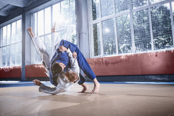 istock Two judo fighters showing technical skill while practicing martial arts in a fight club 1015538322