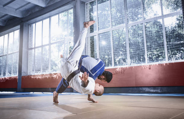 istock Two judo fighters showing technical skill while practicing martial arts in a fight club 1015538504