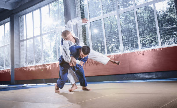 istock Two judo fighters showing technical skill while practicing martial arts in a fight club 1015538720