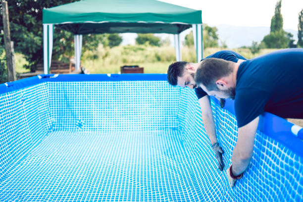 istock Handsome Male Workers Unfolding Outdoor Kiddie Pool 1015542348