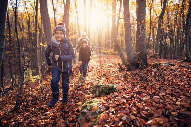 joyeux enfants qui courent dans la forêt d’automne - smiling little girls little boys autumn photos et images de collection
