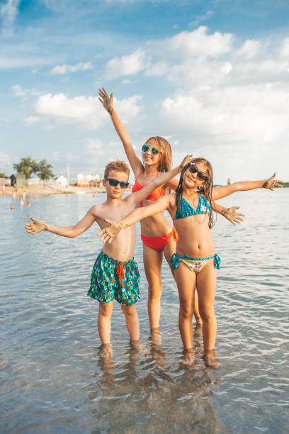 istock Happy children spreading hands on the beach 1015565564