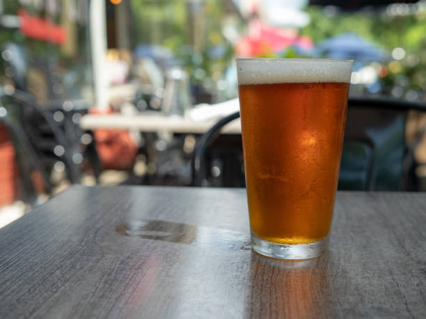 istock Ice cold amber beer sitting in a pint glass on a table outside with wet cup ring 1015585200