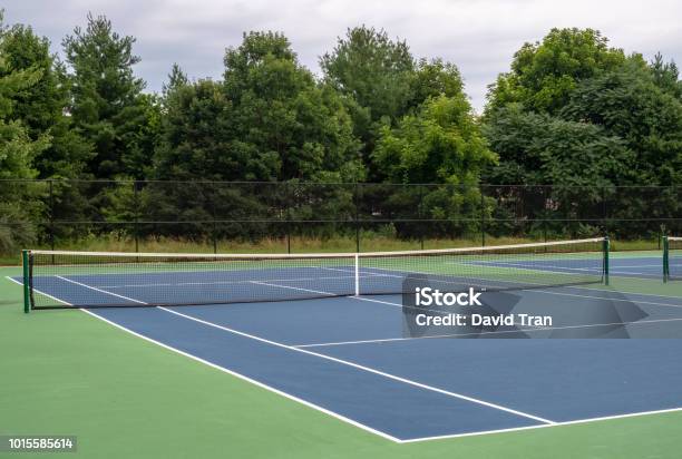 Pequeña Cancha De Tenis De Asfalto Azul Barrio Rodeado De Verde Foto de stock y más banco de imágenes de Tenis