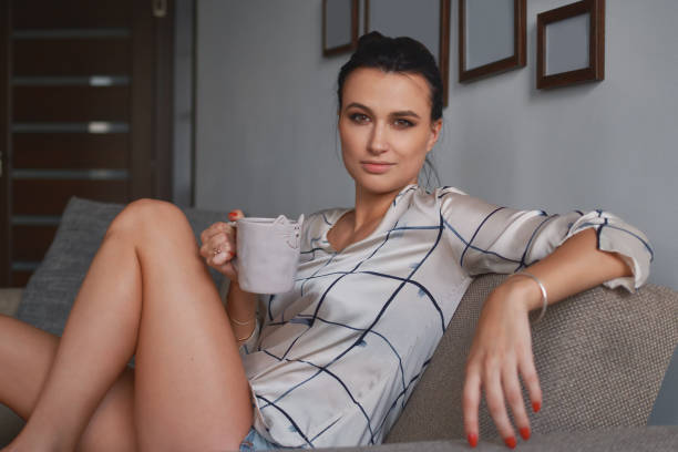 istock Smiling young woman holding a cozy mug with two hands 1015588804