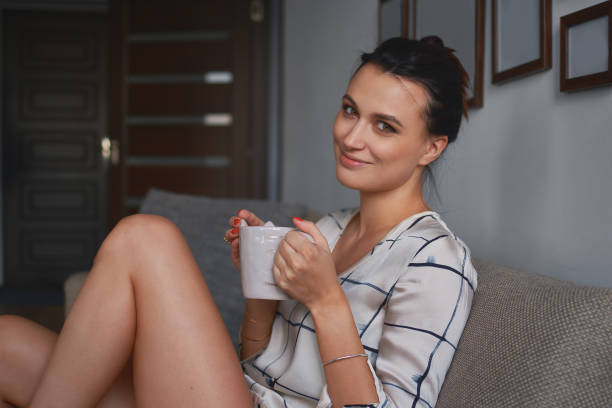 istock Smiling young woman holding a cozy mug with two hands 1015588844