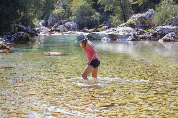 istock Young woman walking in the river Soca 1015589480