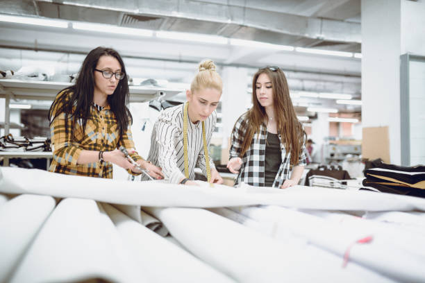 istock Female Textile Factory Workers Cutting And Measuring Materials 1015595036