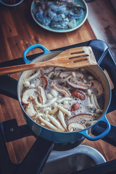 Preparing Tom Yum Goong Nam Kon Thai Soup with Shrimps, Enoki Mushrooms and Fresh Chili
