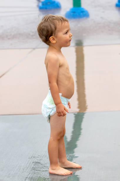istock toddler in diapers in a water playground 1015598396