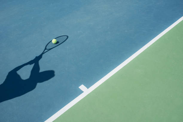 Three tennis balls on a tennis racket at the corner of the lines on blue tennis court. 3D rendering. Flat lay overhead view.