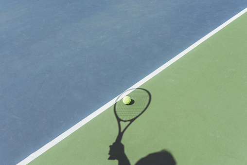 Shadow of Tennis Player catching the ball
