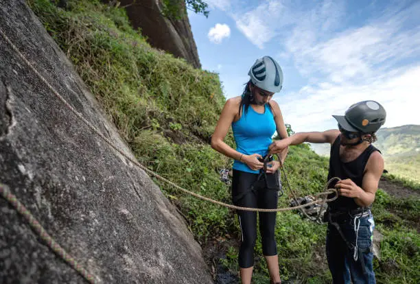 Photo of Woman getting ready for rock climbing and wearing a safety harness