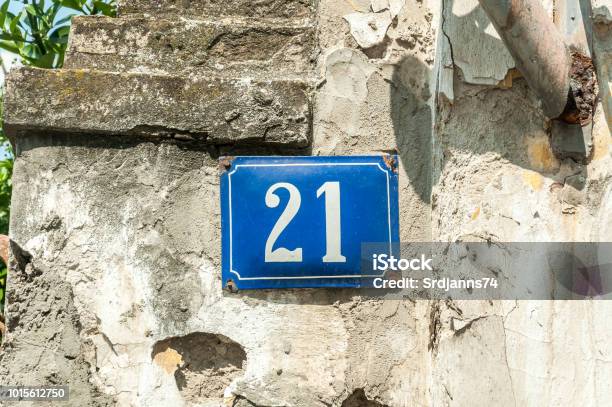 Old Vintage House Address Metal Plate Number 21 On The Plaster Facade Of Abandoned Home Exterior Wall On The Street Side Stock Photo - Download Image Now