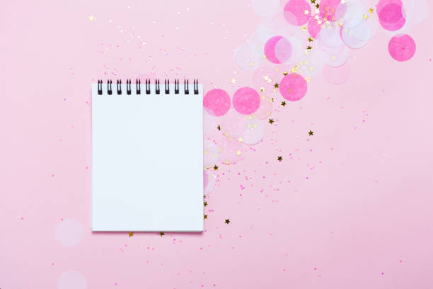 istock Empty note pad on pink festive background with confetti and sparkles. 1015613690