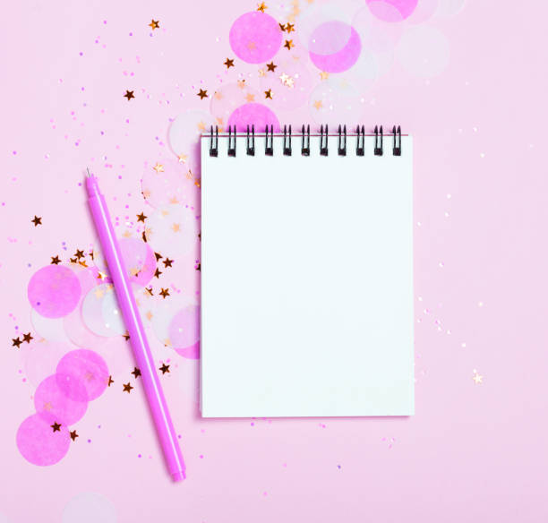 istock Empty note pad on pink festive background with confetti and sparkles. 1015613704