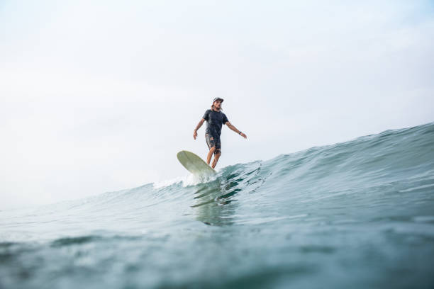 istock young athletic man riding surfboard in ocean during summer vacation 1015621302
