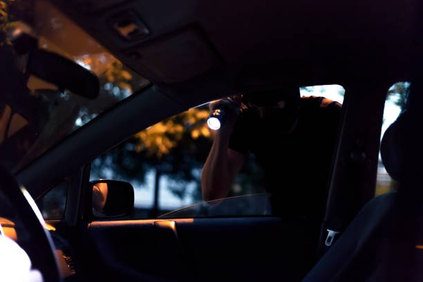 car robber with flashlight - vehicle door flash imagens e fotografias de stock