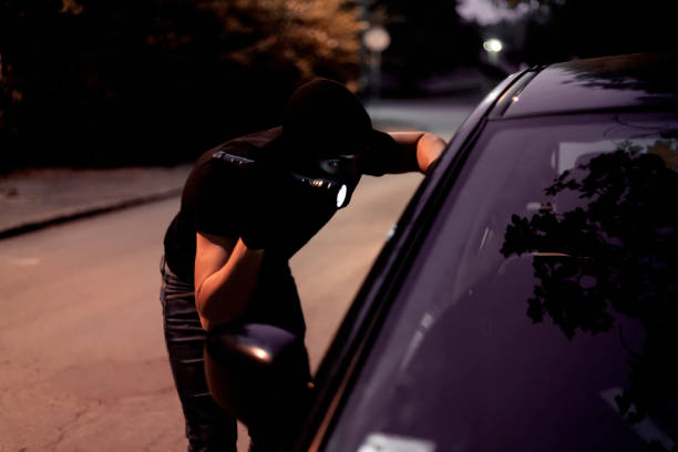 car robber with flashlight - vehicle door flash imagens e fotografias de stock