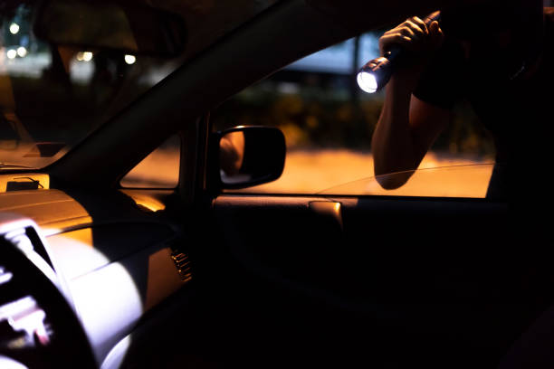 car robber with flashlight - vehicle door flash imagens e fotografias de stock