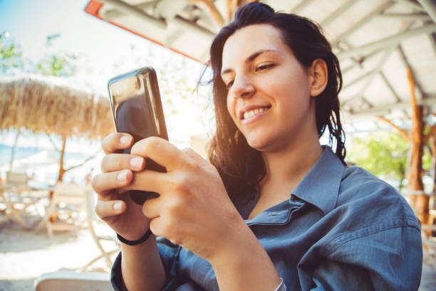 istock Woman using phone on the beach 1015621674