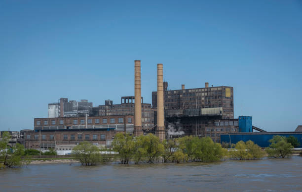A twentieth century factory along the river with two large smokestacks
