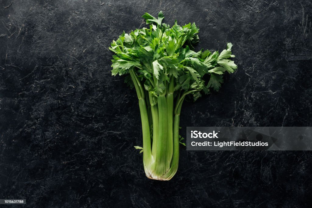 top view of fresh green celery on black marble surface Celery Stock Photo