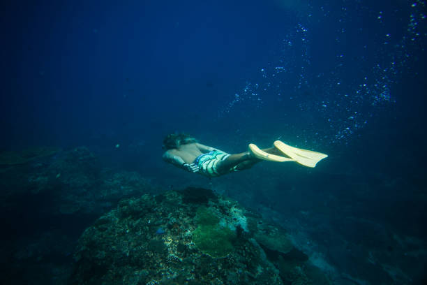 istock side view of man in flippers diving in ocean alone 1015632392