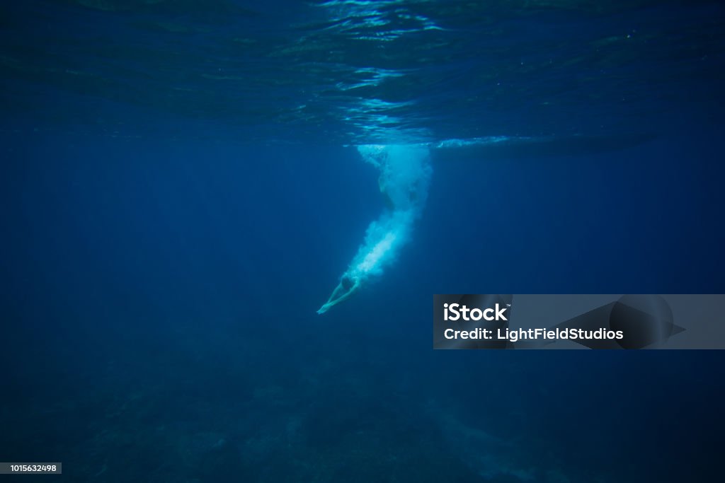 partial view of man diving into ocean Diving Into Water Stock Photo