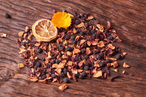 istock Black dry fruit tea leaves on wooden table. Selective focus 1015635226