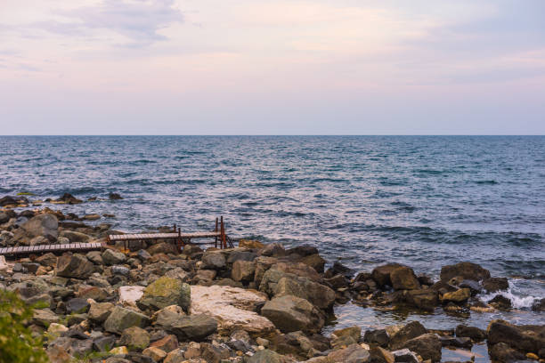 Small bridge by the sea, sunset, stones
