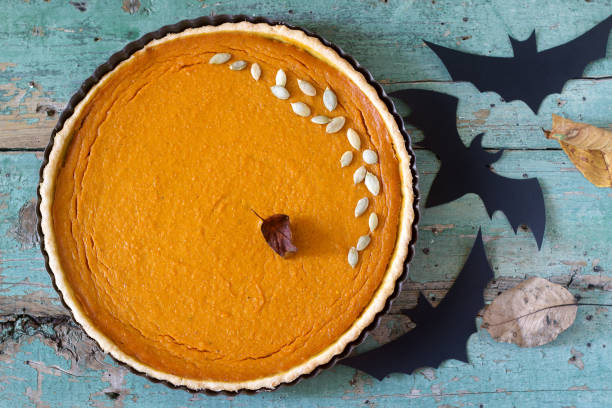 torta di zucca tradizionale americana per il giorno del ringraziamento o halloween su uno sfondo di legno. stile rustico. - healthy eating cake halloween seed foto e immagini stock