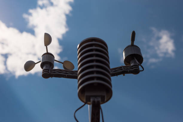 home weather station on a background of blue sky with the sun behind the clouds. measurement of temperature, humidity and wind direction - anemometer meteorology measuring wind imagens e fotografias de stock