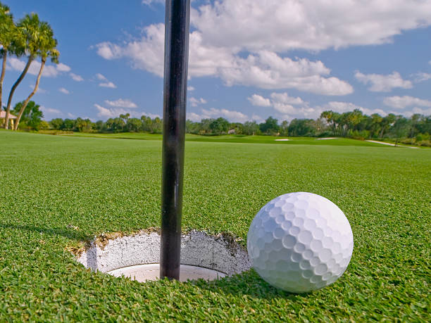 istock golf ball lies just at the hole 101567804