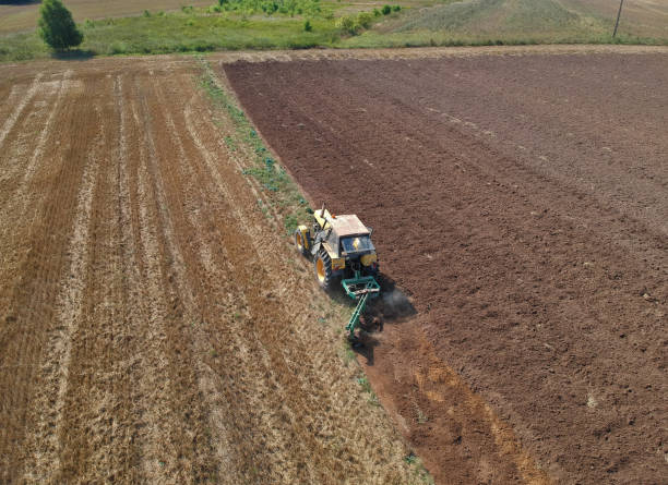 istock Aerial view on old tractor while plowing the soil after crops 1015679698
