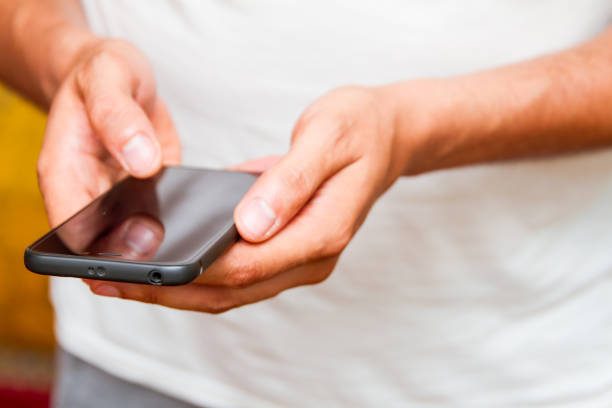 istock Male hands using smartphone. person holding a tactile mobile smartphone 1015684238