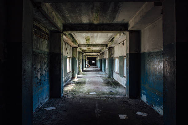 istock Long empty dark corridor in abandoned industrial building, perspective 1015689890