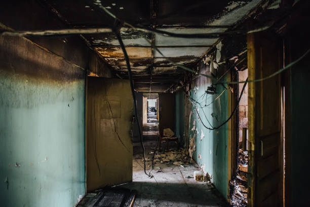istock Dirty empty dark corridor in abandoned building, broken doors, garbage, perspective 1015689898
