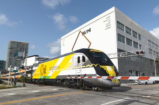 The BrightLine leaving Miami on a sunny morning. This is a new and modern express intercity higher-speed train in Florida, United States. In the near future, this train will connect Miami to Orlando in about 3 hours, although at the current stage it only runs between Miami and West Palm Beach with an​ intermediate stop at Fort Lauderdale.