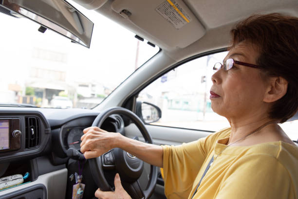 femme senior japonaise, conduire une voiture - japan serious family senior adult photos et images de collection